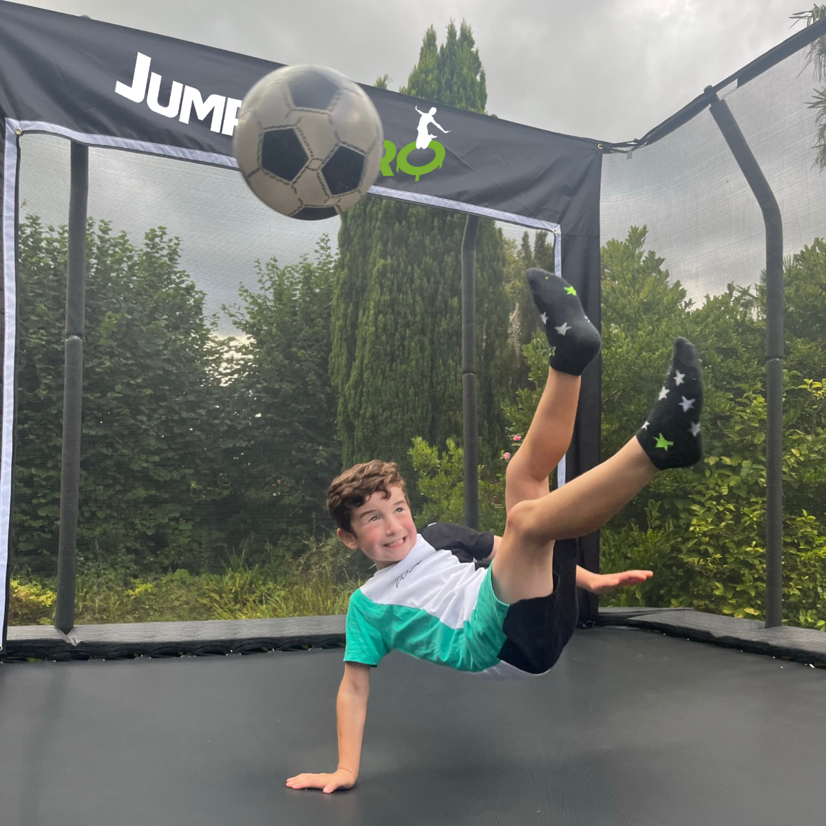Child playing football on a trampoline